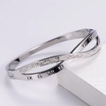Dettaglio macro del bracciale incrociato argento con numeri romani e cristalli pavé - Color Acciaio