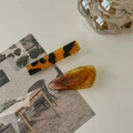 Detail view of retro amber tortoiseshell hair clips with elegant marble patterns set - Amber
