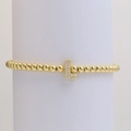 Close-up of gold beaded bracelet with a micro-paved cubic zirconia letter L charm - L