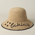 Detail of raffia sun hat featuring black star embroidery and script lettering on brim - M (56-58cm) / Beige