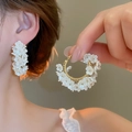 Close-up of elegant gold hoop earrings with white shell flower details on a model - Clustered Flower Garland C-Shape Earrings (7#银针-金色-白色)