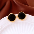 Detail of square flocked stud earrings with gold metal frame on a white porcelain plate - Black