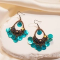 Detail of vintage bohemian earrings with purple beads and blue shell discs on white stone - Ear Hook - Green