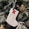 White knitted Christmas stocking with red embroidered letter K hanging on a snowy tree - Embroidered Knitted Small Sock White K