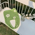 Nahaufnahme einer grünen Häkeltasche mit weißen Blumen auf einer Gartenbank - Gelbgrün