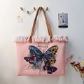 Detail view of pink butterfly print fringe tote bag hanging on a light colored wall - Pink Butterfly Print / 47x35x13cm