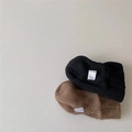 Close-up of ribbed knit texture on stylish black and brown winter beanies with labels - Random