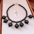 Detail view of a black acrylic beaded necklace with seven round sphere pendants on linen - Beaded Pendant Necklace (Necklace - Black)