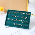 Dark green velvet jewelry tray displaying various earrings on a marble surface - 4-Section Earring Tray