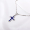 Close-up of silver cross pendant featuring intricate blue and clear gemstone settings - Blue