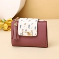 Dettaglio del portafoglio corto rosa con stampa a foglia e nappa decorativa - Rosa Intenso