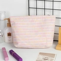 Detail van de roze tweed make-uptas met gekleurde strepen en gouden metalen rits - Roze