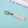 Detailed close-up of a pink faux leather tassel keychain with gold-tone metal ring - Pink