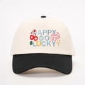 Vorderansicht der Kontrast-Baseballkappe mit Happy Go Lucky Stickerei und Würfelmotiven - Creme/Schwarz