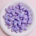 Macro shot of purple iridescent bow-shaped acrylic beads for DIY jewelry making - Purple