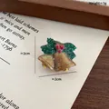 Christmas resin brooch featuring golden bells and holly leaves with festive glitter - Bell