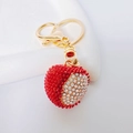Dettaglio portachiavi a forma di cuore con strass rossi e finiture in metallo dorato - Litchi