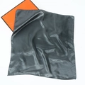 Detailed view of dark grey square silk scarf draped over a bright orange gift box - 60*60cm / Dark Gray