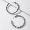 Detail van zilveren C-vormige oorringen met pavé-diamantjes op een wit platform - Zilveren Cirkel Oorbellen