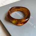 Close-up of amber acrylic resin bangle with tortoiseshell pattern on a book cover - 91# Bracelet-Amber Tortoiseshell Angular