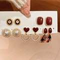 Primo piano di cinque paia di orecchini vintage in perle di resina con cuori e fiori - Set Mix Rosso Bianco Oro (10 Pezzi/5 Paia)