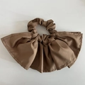 Primo piano dettagliato che mostra la trama del tessuto satinato marrone dell'elastico - Marrone