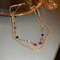 Detail of a double-layer gold chain necklace with colorful round crystals on a gold tray - 84# Multicolor Double Layer Style
