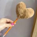 Close-up of cute camel heart plush ball on an orange plastic creative ballpoint pen - Khaki