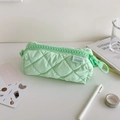 Close-up of mint green quilted pencil case with oversized plastic zipper and woven label - Green