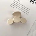 Primer plano de pinza para el pelo color crema con diseño minimalista sobre tela suave - Albaricoque