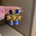 Vintage gold earrings with blue drop pendants and bow design held in hand - Blue Water Drop Bowknot Style (38#)