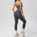 Detail view of charcoal grey cross-back yoga set showing seamless fabric and sculpting fit - Graphite Grey