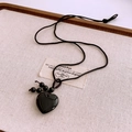 Detailopname van gepolijste zwarte hartvormige hanger aan een geweven zwart koord - Obsidiaan Hart Hanger (WN1478)
