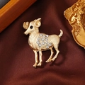 Vintage golden Aries ram brooch with sparkling rhinestones on luxury silk background - Aries
