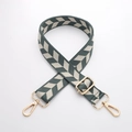 Detail view of woven bag strap with green geometric patterns and golden metal clasps - J44-A4-Green Beige Herringbone / Light gold