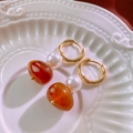 Close-up of vintage resin geometric earrings with gold hoop and faux pearl on ceramic plate - Gold Amber Pearl