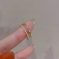 Juego de tres anillos bañados en oro con perlas y circonitas en la mano de modelo - Juego de Tres Piezas (Dorado) / Dorado