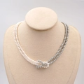 Elegante collana di perle a doppio filo con nodi grigi e bianchi su un busto gioiello - Collana / Bianco / Grigio
