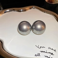 Close-up of elegant silver-grey pearl stud earrings on a decorative ceramic dish - 67# Gray Bread Pearl