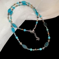 Dettaglio della collana di perle colorate con perle blu cielo e turchese sulla seta - Blu