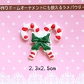 Detailed close-up of a Christmas candy cane resin charm with red stripes and green bow - Connected Candy Canes - Red
