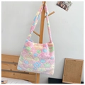 Pink plush tote bag with colorful flower patterns hanging on a wooden hanger - Pink