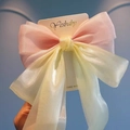 Detailed close-up of large pastel organza bow hair clip on a white branded display card - Pink and Yellow Patchwork