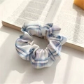 Blue and purple plaid floral scrunchie hair tie on a book with soft natural lighting - JK Xingye