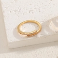 Luxuriöser 14K vergoldeter Bypass-Ring mit Zirkonia-Mikropavé auf Steinhintergrund - Überkreuzte Wicklung Ring
