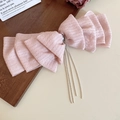 Detail of pink bow hair clip featuring textured lace fabric and silver bead tassels - Pink Bowknot Tassel Spring Clip