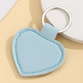 Close-up of light blue heart-shaped leather keychain with lychee texture and silver ring - Heart Shape / Light Blue