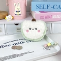 Dettaglio ravvicinato di un portamonete a mela in peluche verde con un dolce sorriso ricamato - Circa 9 cm / Mela verde sorridente