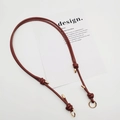 Close-up of reddish brown leather bag strap with golden rings and knot details - Gold Ring Buckle / Dark Brown