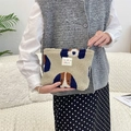 Close-up of plush fleece makeup bag with dog pattern and branded fabric label - Camel Dog Pattern